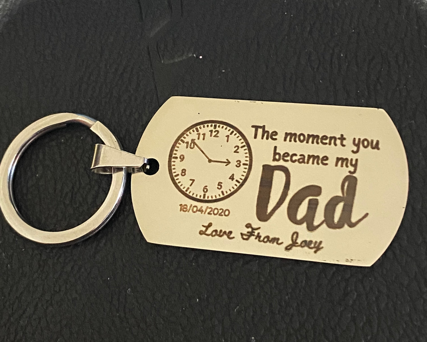 Keychain with engraved message on a black textured background