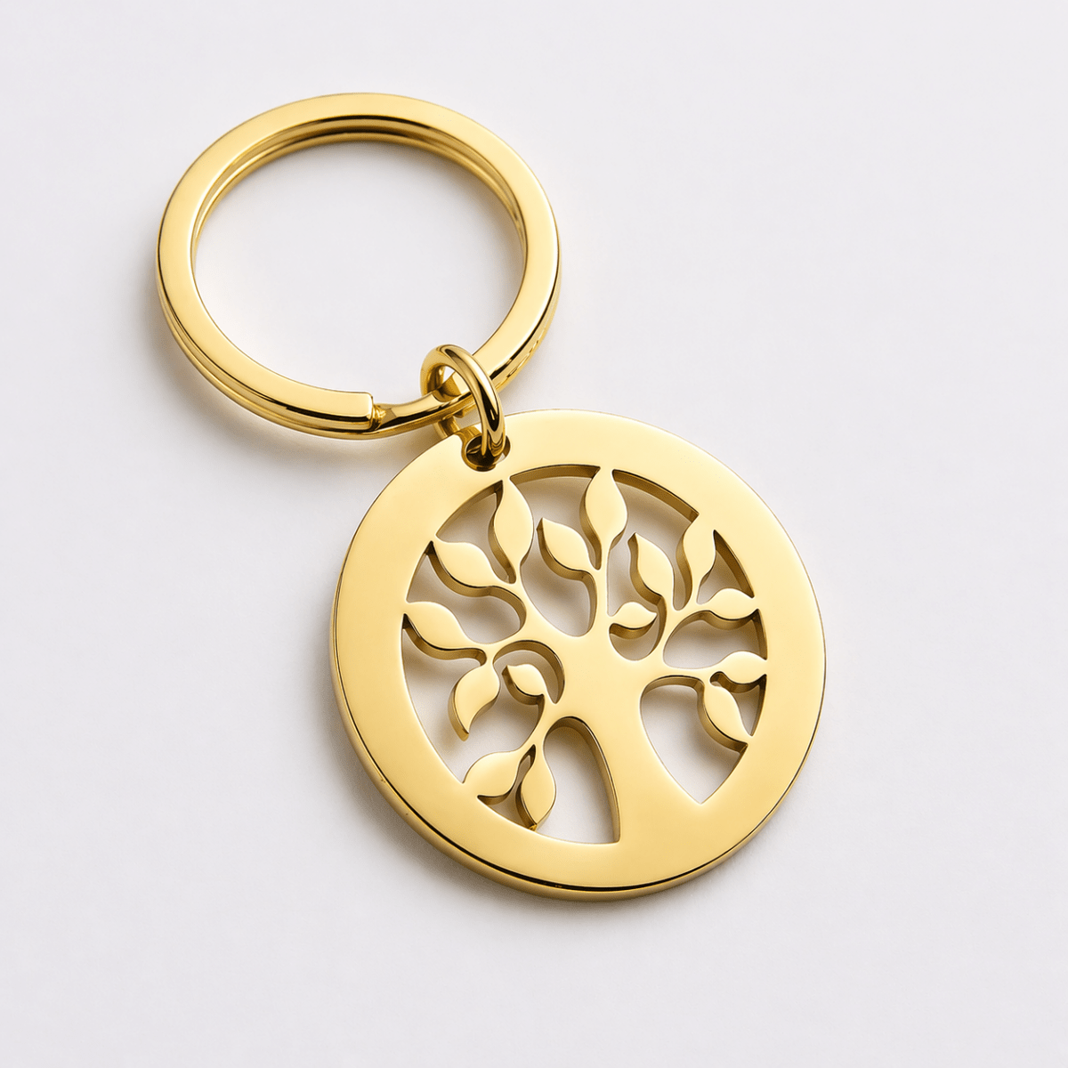 Gold keychain with tree design on a light gray background