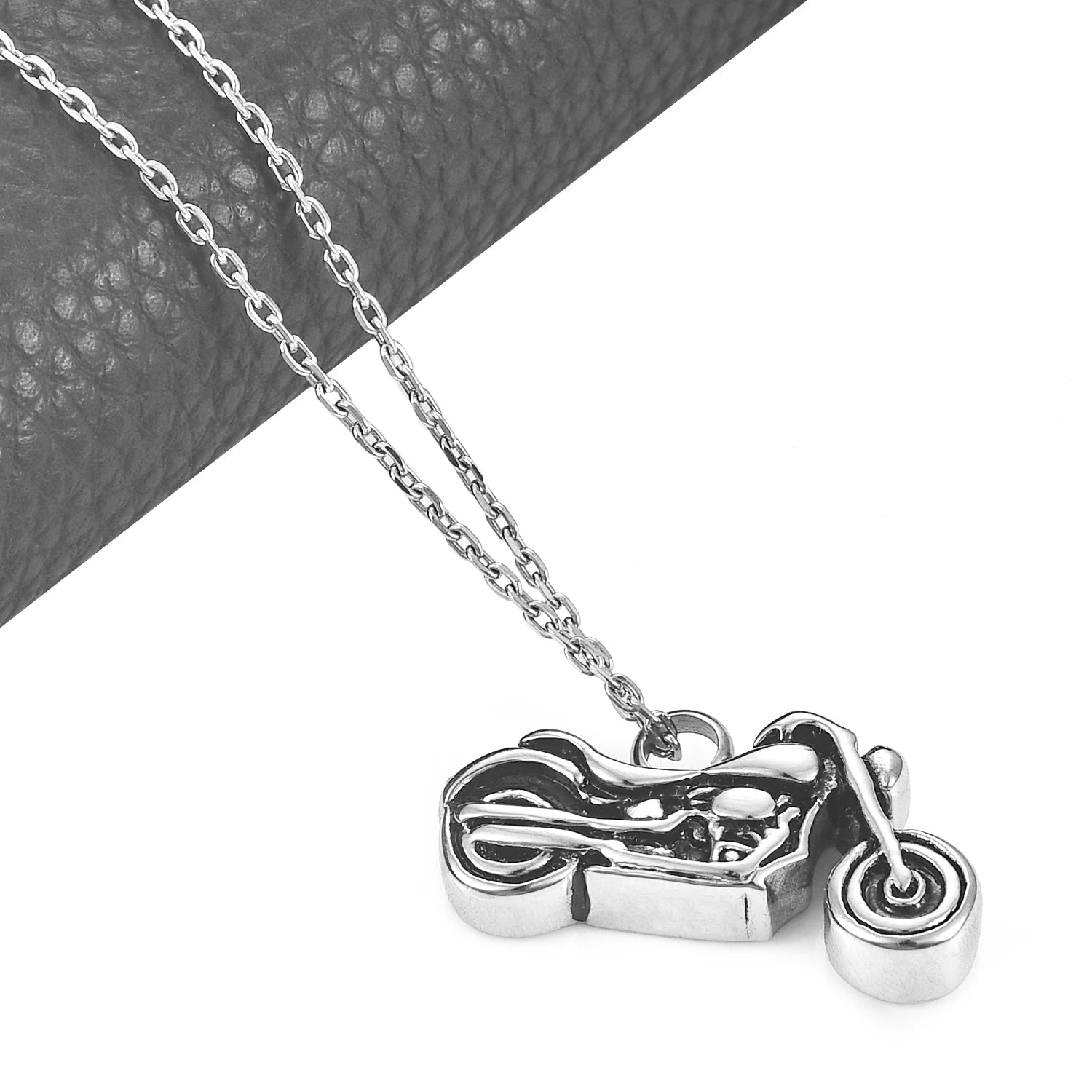 Motorcycle pendant necklace on a chain against a neutral background