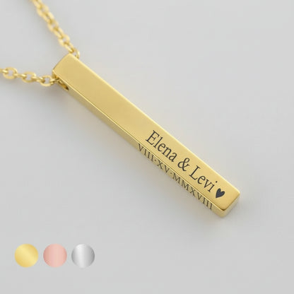 Gold bar necklace with engraved names on a light background
