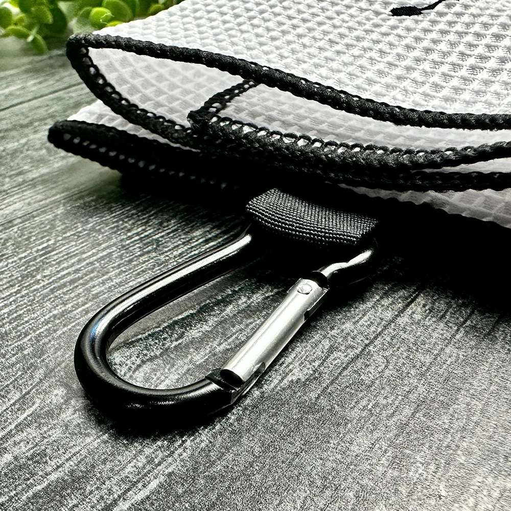 Close-up of a black rope with a carabiner attached to a white textured surface.