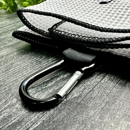 Close-up of a black rope with a carabiner attached to a white textured surface.