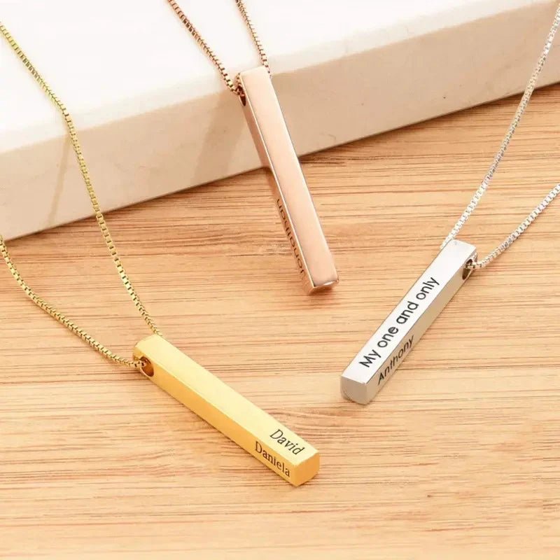 Three necklaces with vertical bars engraved on a wooden surface