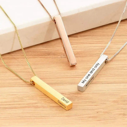 Three necklaces with vertical bars engraved on a wooden surface