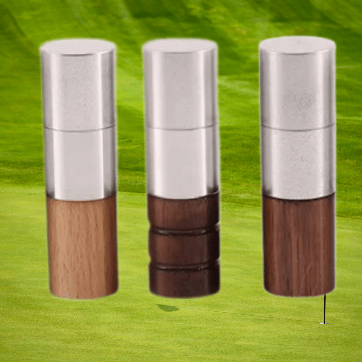 Three deluxe ball marker stamps with silver top and wooden bottom on a green background