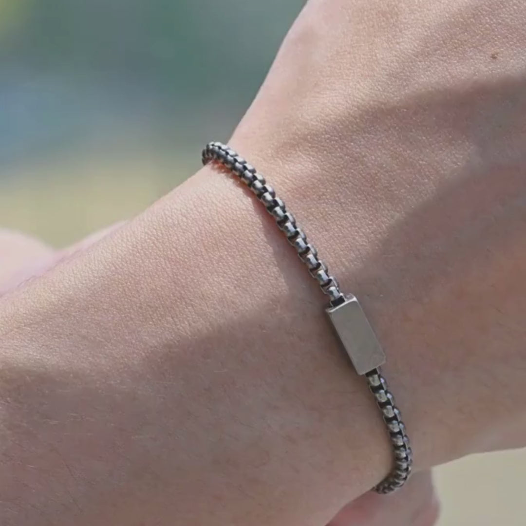 Load video: video showing mens bracelet on mans wrist, shows bracelet being secured with a close up of the quality clasp, shows bracelets strength with a tugging motion